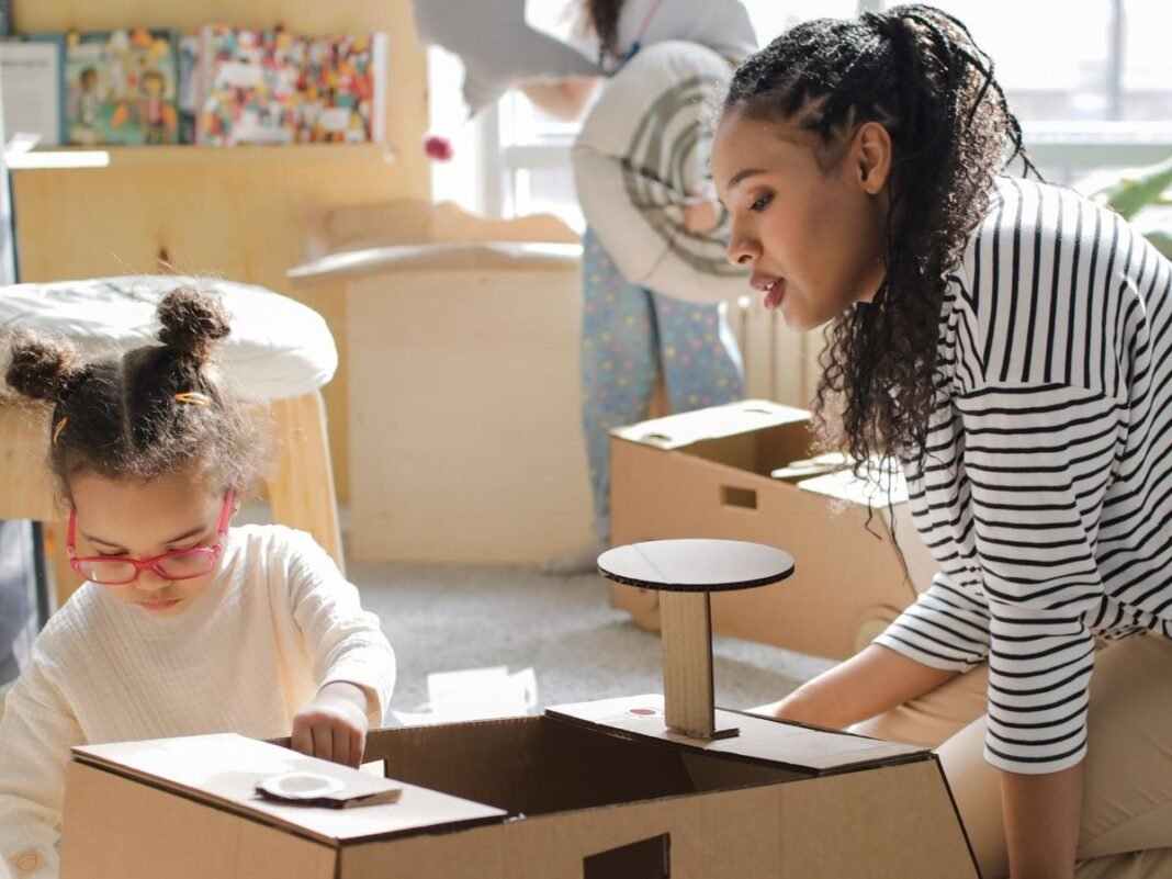 Adult and children playing with handmade cardboard toys